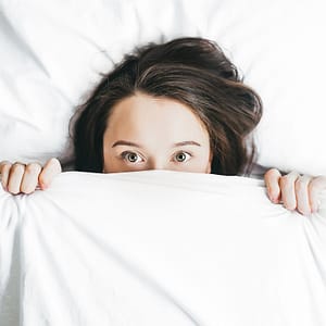 Fear causing woman to hide under sheets